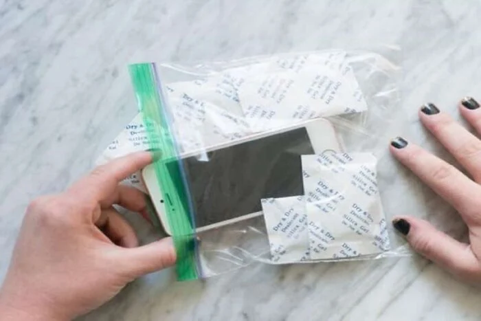 a smartphone and several packets of silica gel inside a plastic bag